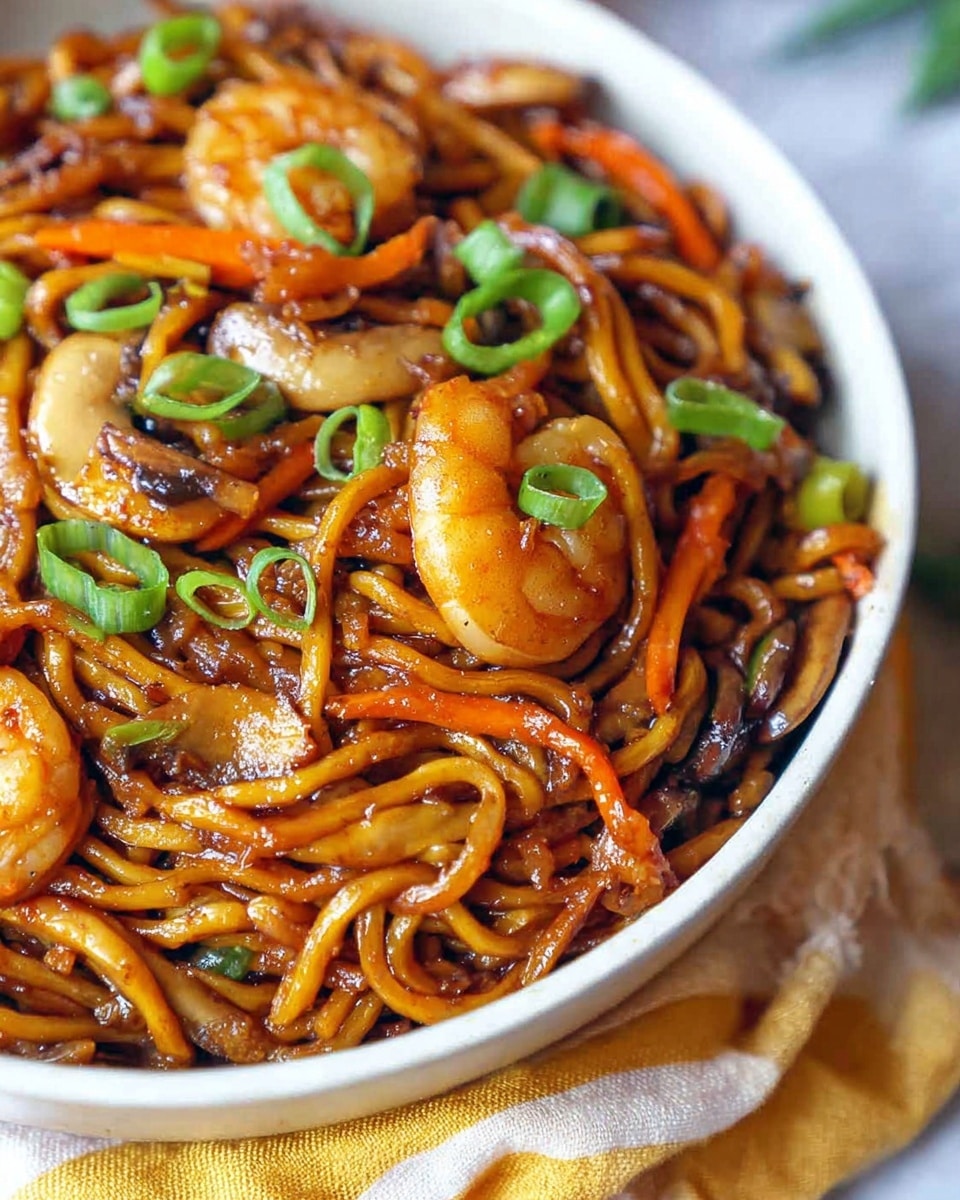 A close-up view of a bowl filled with glossy, brown stir-fried noodles mixed with orange carrot slices and light brown cooked mushrooms, topped with scattered green onion pieces. Among the noodles, there are visible golden-brown shrimp adding texture and color contrast. The bowl is white and sits on a soft white marbled surface with a hint of a yellow and white cloth beneath. The image focuses tightly on the food, showing a shiny, slightly oily texture on the noodles with vibrant colors from the vegetables and shrimp. Photo taken with an iphone --ar 4:5 --v 7