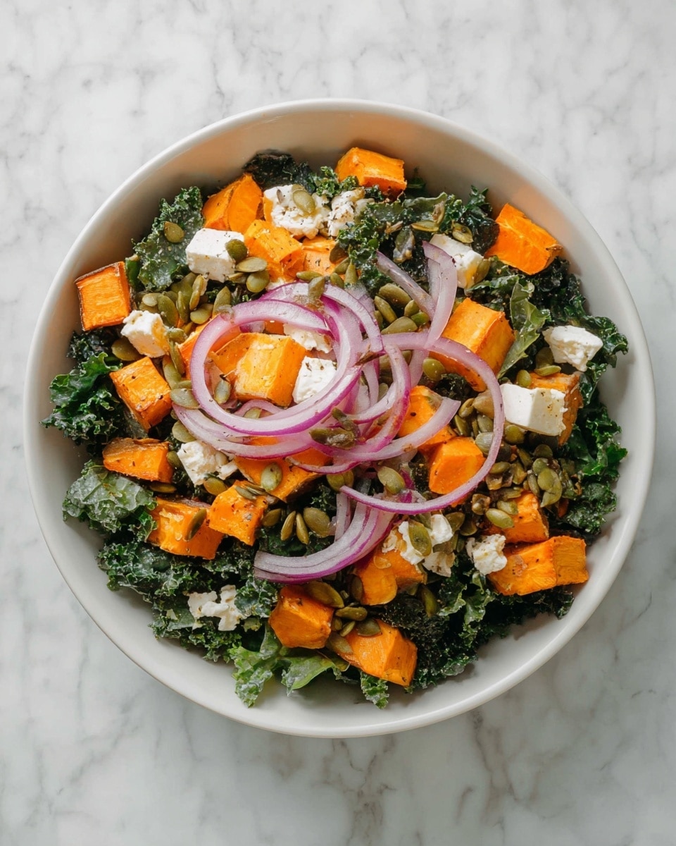 A white bowl filled with a fresh salad on a white marbled surface. The bottom layer is dark green curly kale leaves, adding a textured leafy base. On top, there are bright orange cubes of roasted sweet potatoes scattered evenly, creating a warm contrast. Thin slices of purple-red onion rings are placed on top, adding a pop of color and a soft texture. Scattered across the salad are small chunks of white cheese crumbles, giving a creamy element, and green pumpkin seeds, which add a crunchy, flat texture throughout the dish. photo taken with an iphone --ar 4:5 --v 7