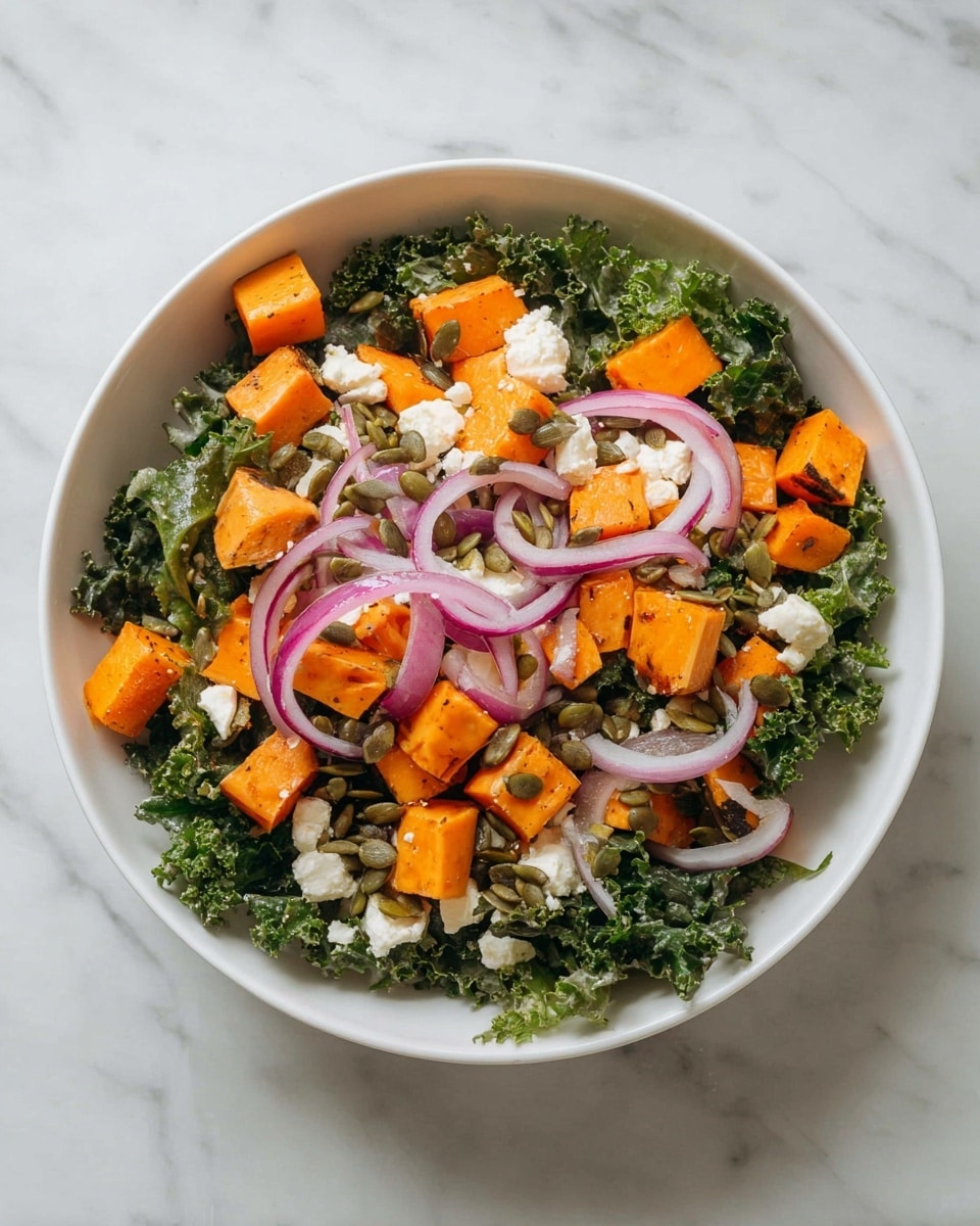A metal bowl filled with a colorful salad sits on a white marbled surface. The base layer shows dark green kale leaves with a slightly rough texture, covering the bottom of the bowl. On top, there are bright orange chunks of roasted sweet potato cut into small cubes, evenly spread around. Thin rings of purple-red onion lay above the sweet potatoes, adding a fresh and crisp texture. There is a generous amount of white crumbly cheese clustered in the center. Scattered over everything are light green pumpkin seeds adding a crunchy texture. A woman's hand is gently holding the bowl from the bottom edge. photo taken with an iphone --ar 4:5 --v 7