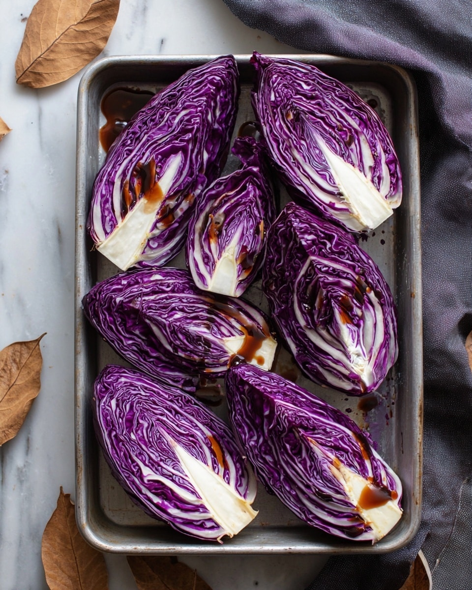 The image shows a metal baking tray holding eight pieces of purple cabbage, each cut into thick wedges with visible layers of deep purple and creamy white veins. A dark brown sauce is drizzled over the cabbage, creating shiny spots and small puddles on the tray. The cabbage wedges are arranged in a scattered way, showing their textured, curled leaves and firm white stems. Around the tray, there are some dry, brown leaves and a dark grey cloth on a white marbled surface. photo taken with an iphone --ar 4:5 --v 7