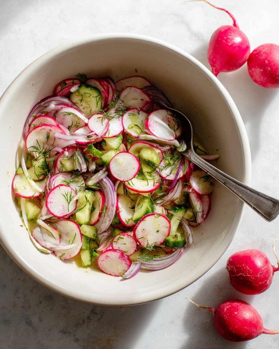 A white bowl filled with a fresh salad showing three main layers: thin round slices of red radish with white centers and red edges spread throughout, thin slices of pale purple onion strips resting lightly among the radish, and small green cucumber chunks mixed evenly in between the layers. Fresh green herb sprinkles are scattered over the top, giving a lively touch. A silver spoon is partially placed in the bowl on the right side. The bowl rests on a surface with a white marbled texture, with two whole radishes placed nearby casting soft shadows. Photo taken with an iphone --ar 4:5 --v 7
