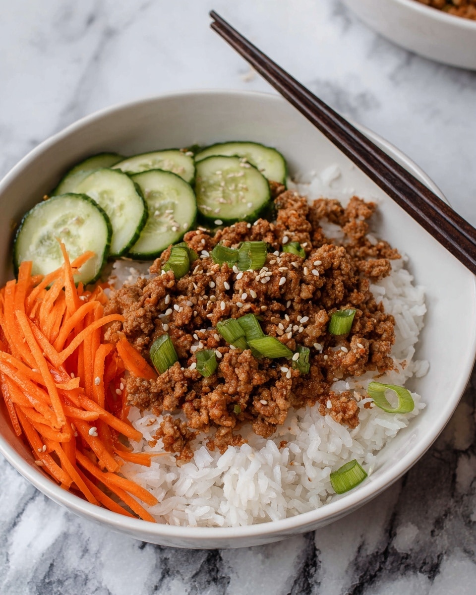 A white bowl contains three main layers: at the bottom is a bed of soft white rice, topped with a layer of cooked, crumbly ground meat seasoned with brown sauce and sprinkled with white sesame seeds and sliced green onions. To one side, bright orange shredded carrots add a fresh, crunchy texture, while sliced green cucumbers with visible seeds and a light sprinkling of sesame seeds sit adjacent. Dark wooden chopsticks rest on the bowl's edge, all set on a white marbled surface. Photo taken with an iphone --ar 4:5 --v 7