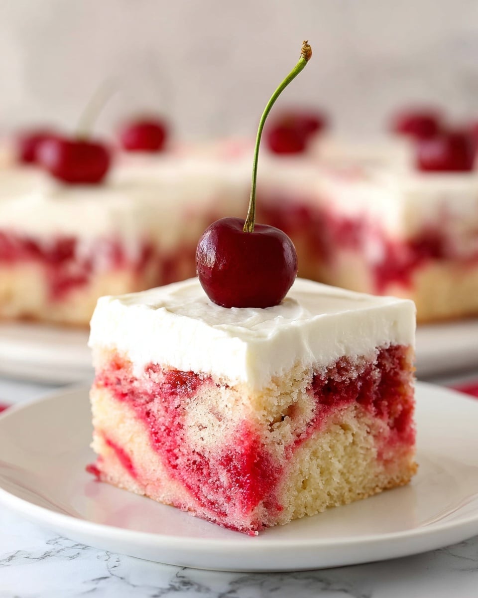 A single square piece of cake sits on a white plate on a white marbled surface. The cake has two visible layers; the bottom layer is moist with pink and pale yellow swirls creating a marbled effect, and the top layer is a smooth, thick white cream frosting covering the entire surface. On top of the frosting, a single shiny deep red cherry with a long green stem stands upright, adding a pop of color. In the background, blurred pieces of similar cake with cherries can be seen, emphasizing the focus on the front slice. Photo taken with an iphone --ar 4:5 --v 7